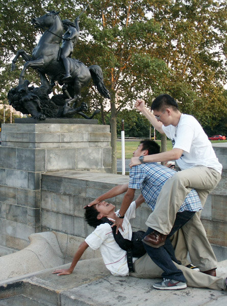 Asian tourists recreate the Lion Hunt Sculpture