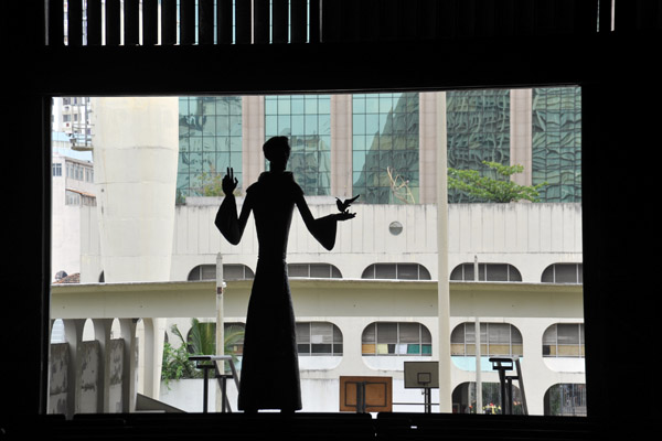 Silhouette of statue by the open door or Rio Cathedral