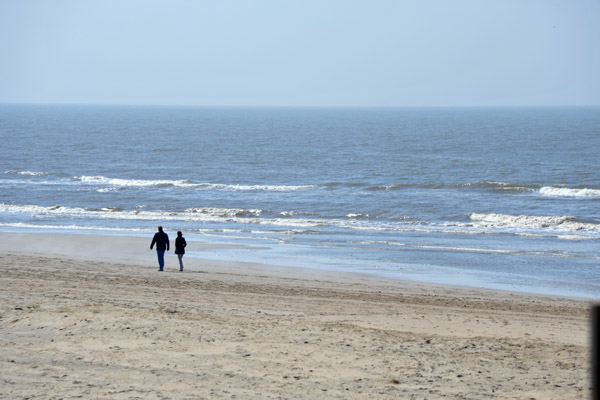 A couple strolling along the beach at Noordwijk mid-April