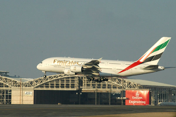 Emirates A380 landing with the new Emirates Engineering Centre
