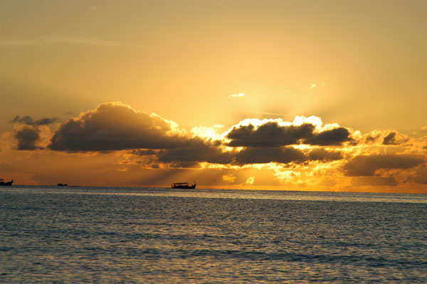 A dhoni sailing at sunset