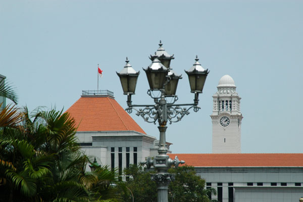 Lamp along the Singapore River with the red roof of Parliament