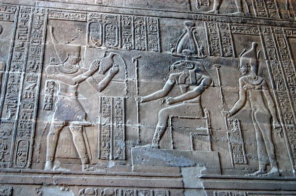 Khnum and Satis, his consort, receiving offerings from king wearing crown of Lower Egypt, the deshret