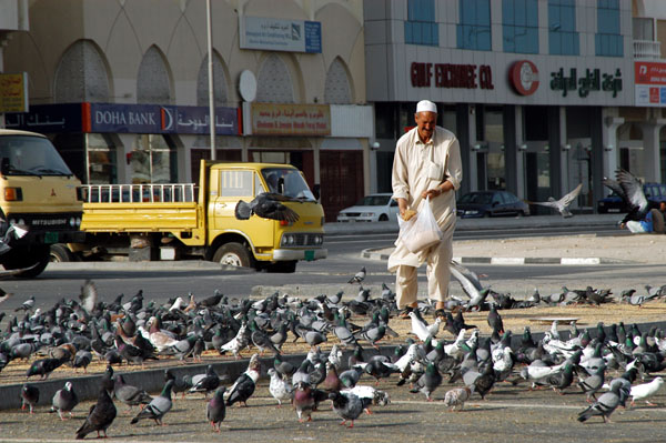 Man feeding pigeons, Ali Bin Mohammed Street, Doha
