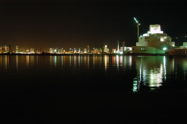 The new Museum of Islamic Arts with the lights of Doha's West Bay area