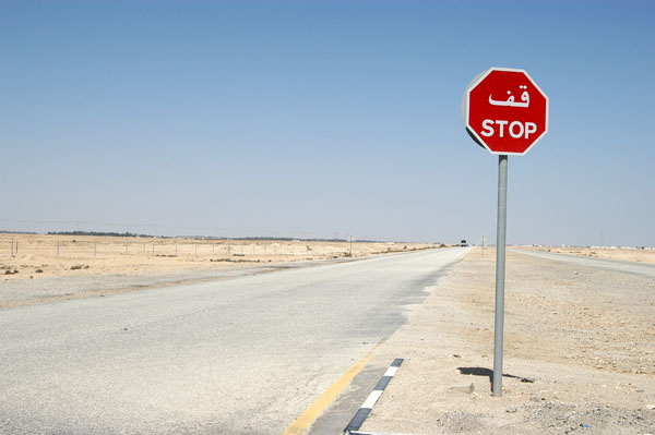 Stop sign on the road to Al Zubara through the desert of northern Qatar