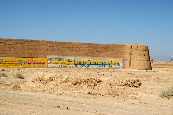 Caravanserai covered with advertising just outside Abarqu