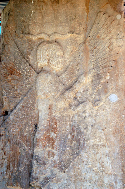 Gate house with 4-winged male figure wearing an Egyptian crown