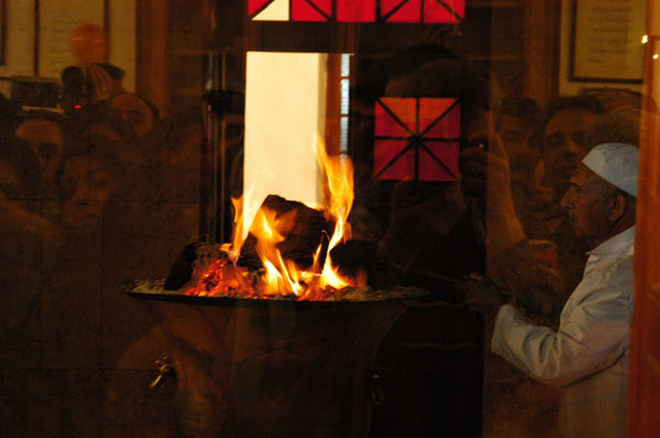 Zoroastrian priest stokeing the sacred flame