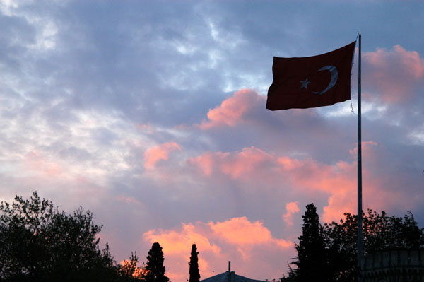 Turkish flag flying over Beyazit Square at sunset