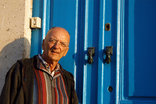 Dad posing with blue Tunisian doors with hand knockers