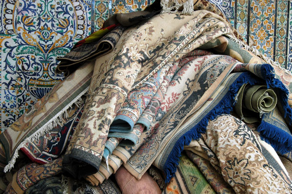 Prayer rugs piled in a corner of the mosque