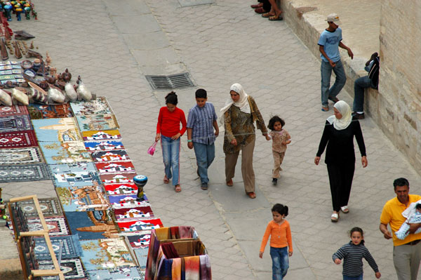 Pedestrians strolling down Rue Okba ibn Nafaa along the wall of the Great Mosque