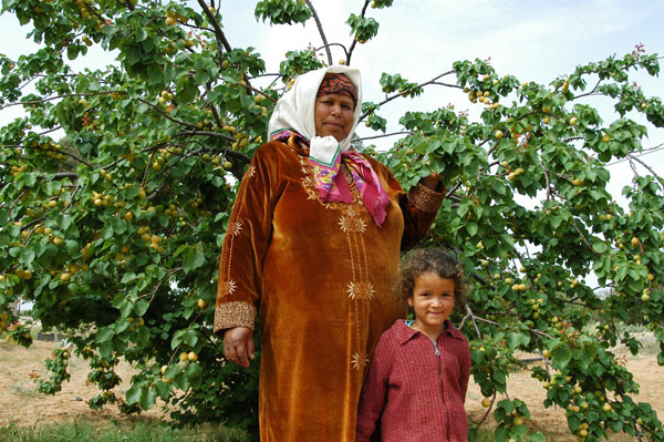 Tunisian woman and her daughter in the apricot orchard