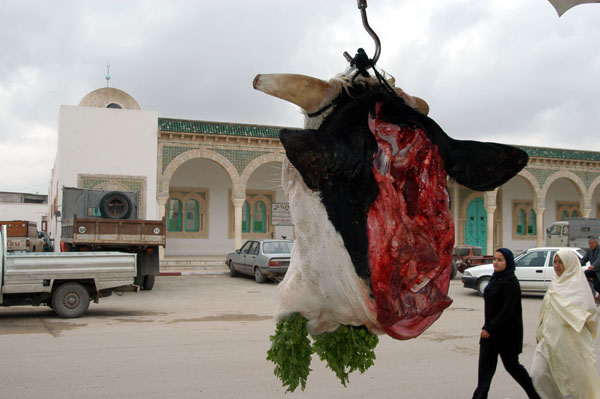 Cow's head advertising fresh beef in front of a butcher shop in El Jem