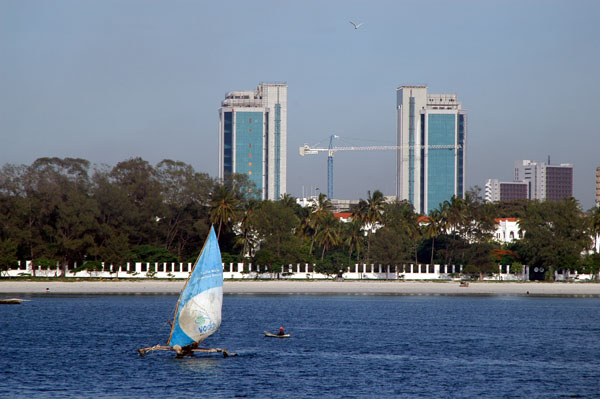 Twin towers of the Bank of Tanzania behind the seafront of Ocean Road, Dar es Salaam with an outrigger sailboat
