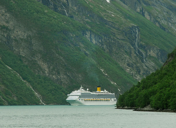 Ocean going cruise ship dwarfed by the mountains of Geirangerfjord