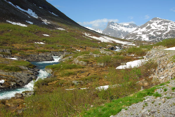 The road climbs from the fertile valley to a harsh alpine environment