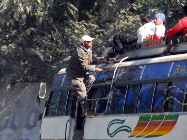 Man climbing to the roof while the bus is in motion