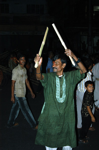 Hindu man banging sticks together, Dhaka