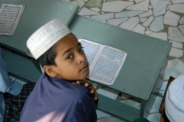 Bangladeshi boy looking up from his desk, Dhaka Medrassa