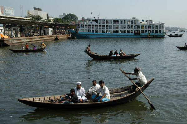 The oarsman uses a single long yuloh to row like a Venetian gondolier while facing forward, Dhaka