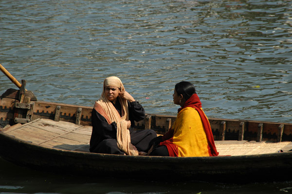 A pair of finely dressed women crossing the river