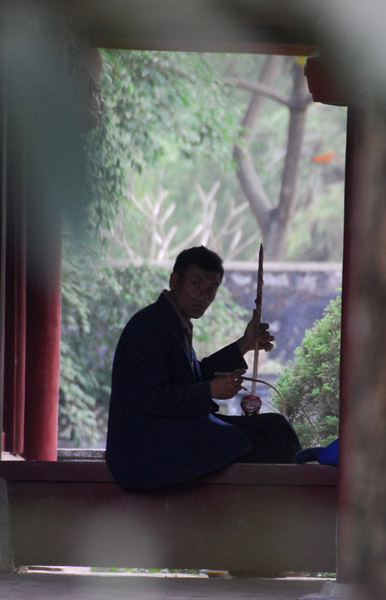 Man playing a one-string traditional instrument, Hoa Lu