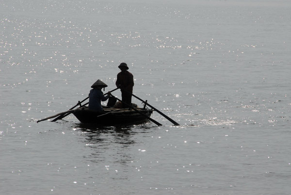 Fisherman in a traditional rowboat, Bach Dang River