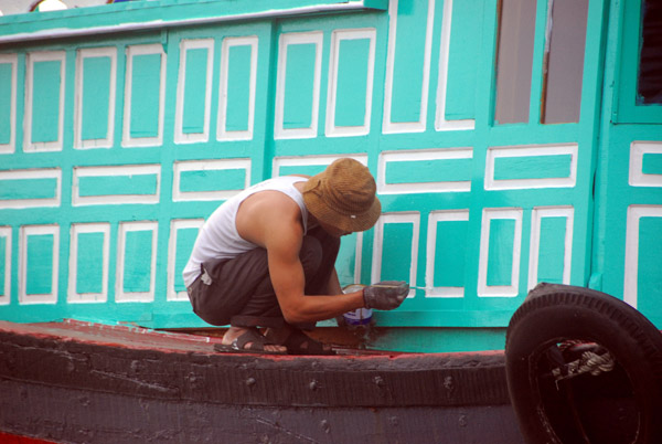 Man painting his fishing boat, Cat Ba floating village