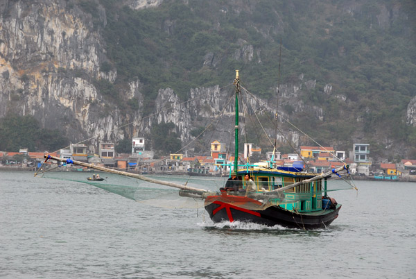 Fishing boat with nets spread leaving Hon Gai