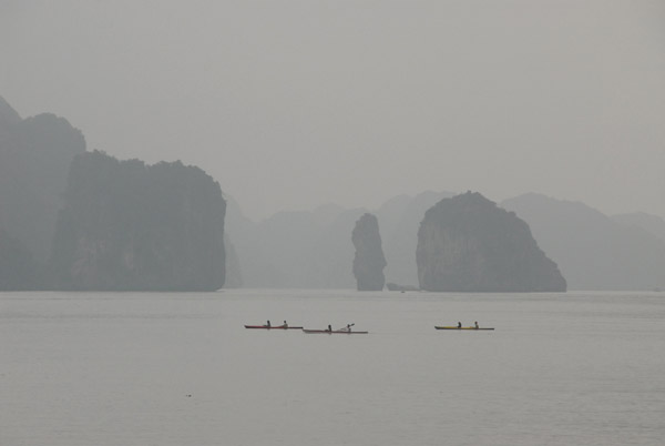 A group of kayakers paddling Halong Bay