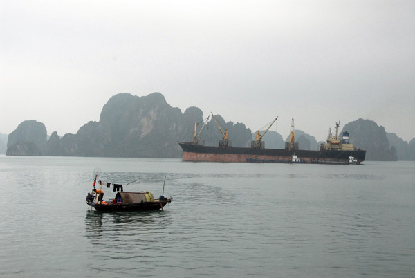 A large bulk cargo carrier either loading or unloading onto smaller cargo vessels