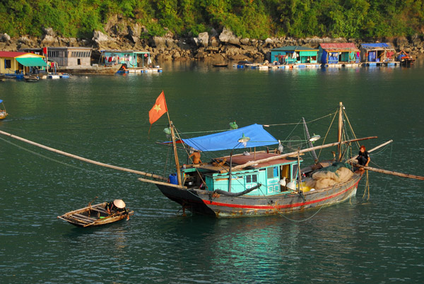 Fishing boat arriving at a floating village, Halong Bay