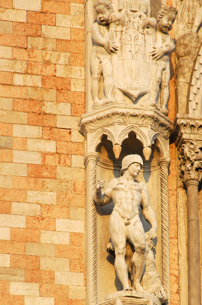 Sculpture of a soldier wearing only a helment, to the left of the central balcony on the west faade, Doge's Palace