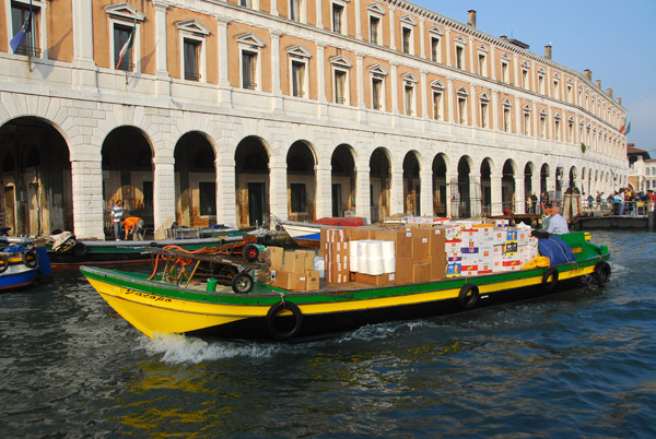 A cargo boat in front of the Fabbriche Nuove di Rialto as it nears the Rialto Bridge