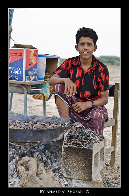 A young kid grilling meat
