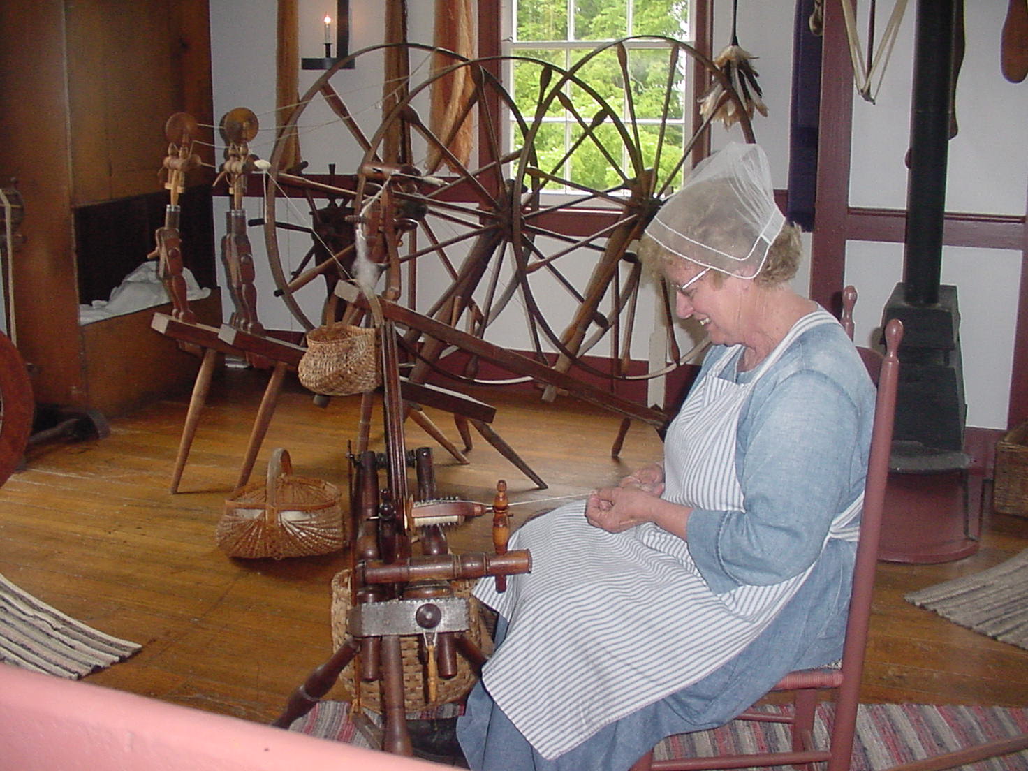Notice the variety of spinning wheels, as a re-enactor spins thread.
