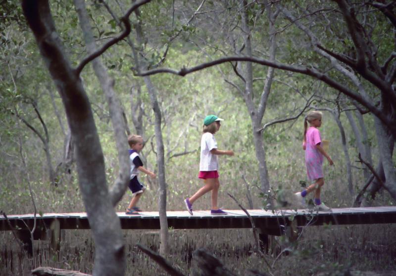 Three children on a boardwalk