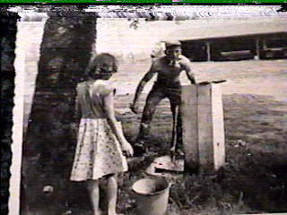 Walt washing up at the faucet and Bobbie looking on.jpg