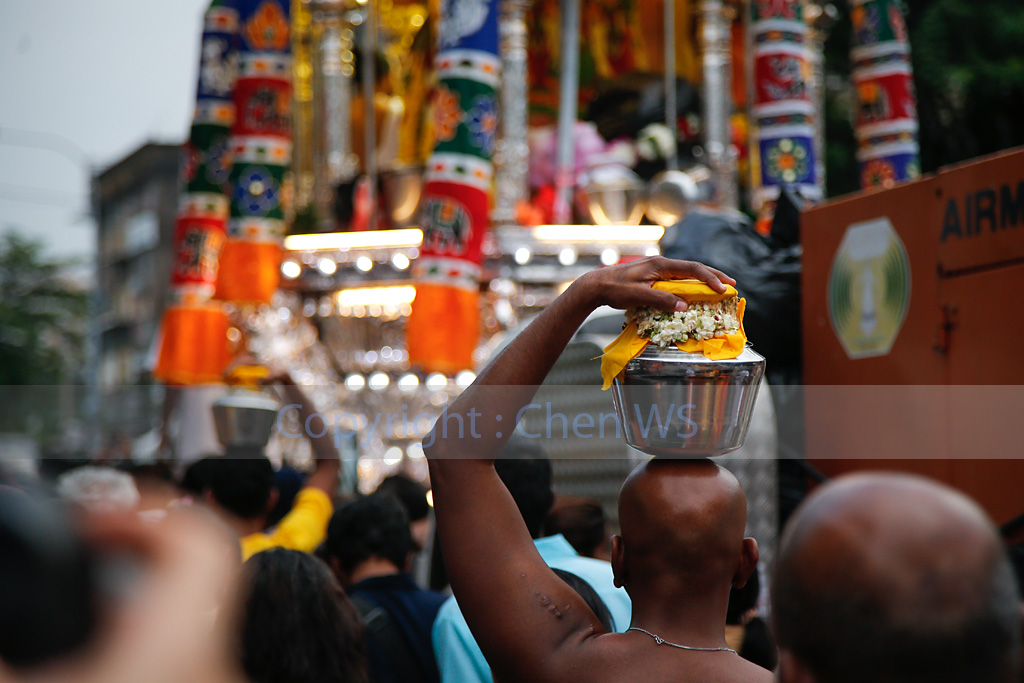 Devotees walking alongside the chariot bearing Lord Muruga