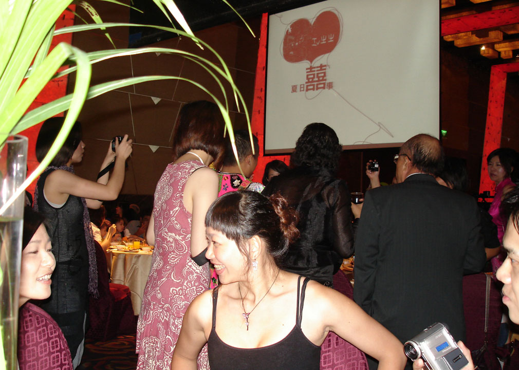 Zhang Xuan peeking around the centerpiece to talk to Lily