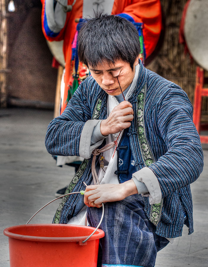 In a remote village, a kung fu performer prepares to pick up a bucket of water. IMG_0365_t2.jpg