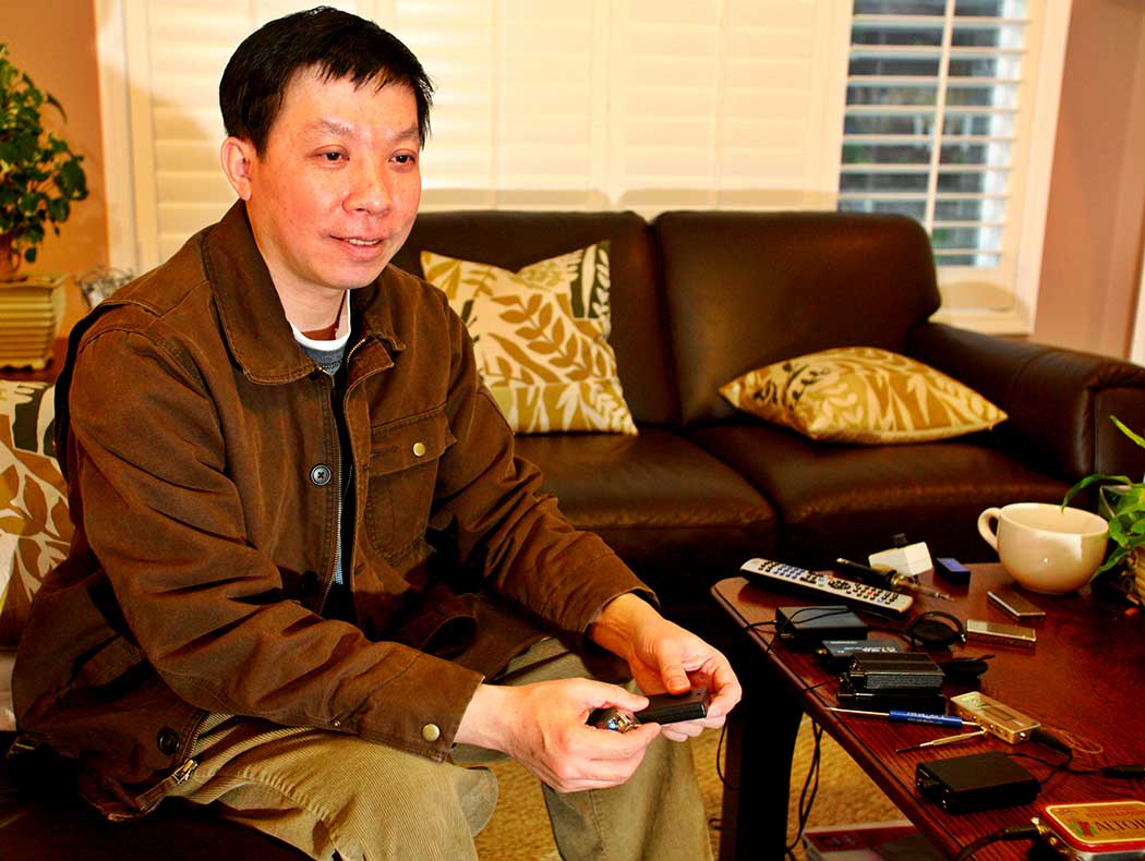Dr. Xin Feng holding holding two of his creations the Micro IV and Mini IV headphone amplifiers.