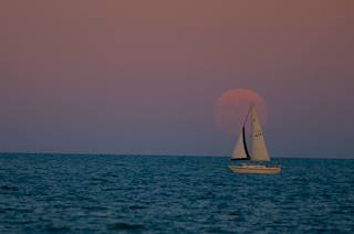 Sailboat in front of full moon
