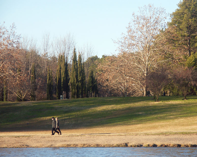 Two public servants walk beside the lake