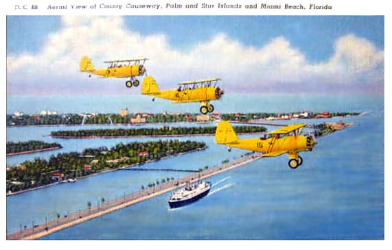 Late 1930s - early 1940s - U. S. Navy N3N Yellow Peril trainer biplanes from NAS Miami over Government Cut, Miami
