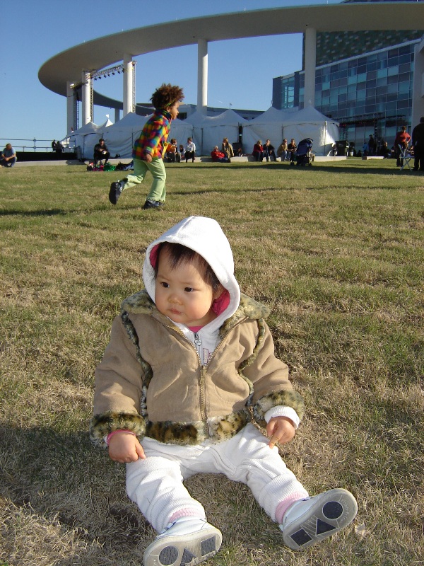 歡歡坐在 Long Center 前的草地上