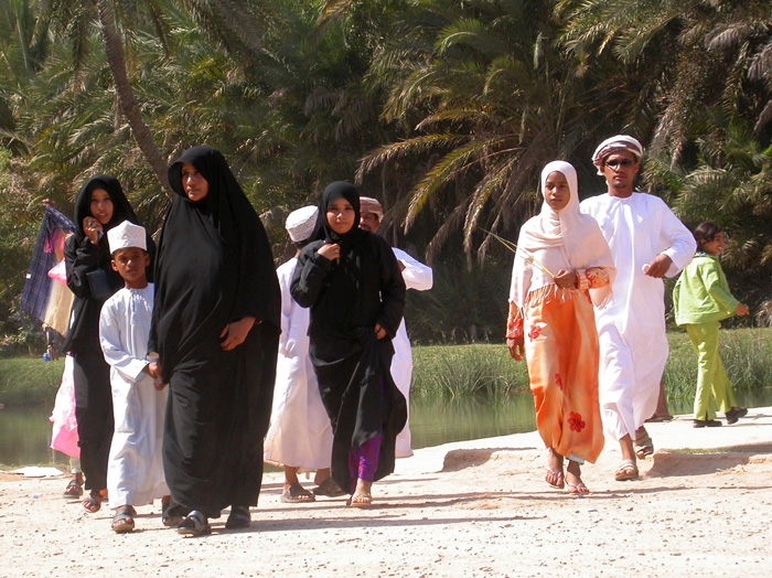 Familj p picknick i Wadi Shab