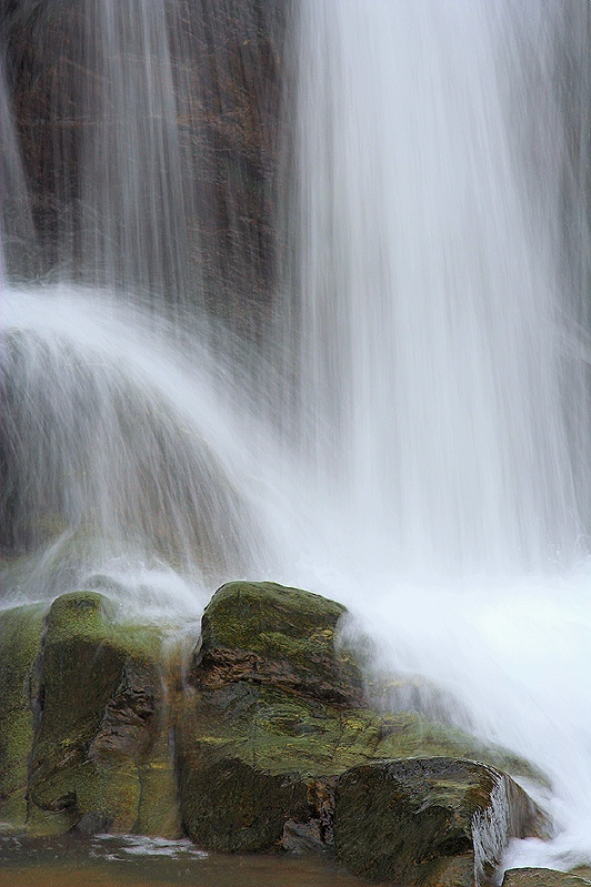 Cascade over mossy boulders